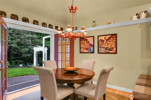 Breakfast nook. High, coffered ceiling with impressive Vaughan® English chandelier. Traditional plate rails. Divided-light French doors with French doors with high-quality customized storm door/screen door system, leading to private back yard backing to forested Nickel Creek Park, and extended aggregate patio.