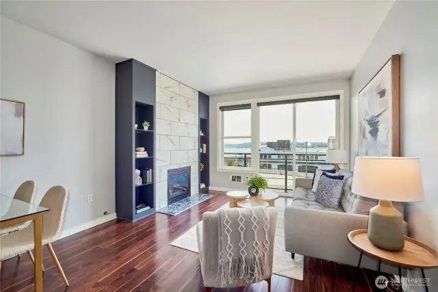 The living room is centered around the floor to ceiling gas fireplace with modern tile, granite hearth and built in shelving. The large west facing wall of windows (with slider to the deck) bathe the space in light and highlight the rich Cherry hardwood floors.
