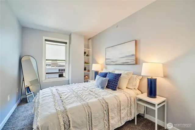 The spacious bedroom offers plush carpet, lovely views, built in shelving and a walk in closet!