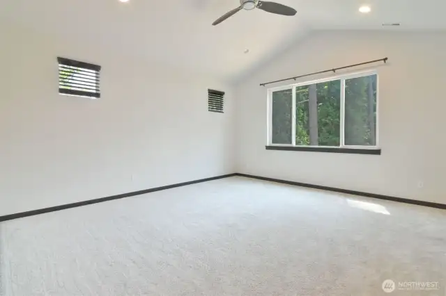 Primary bedroom with vaulted ceiling