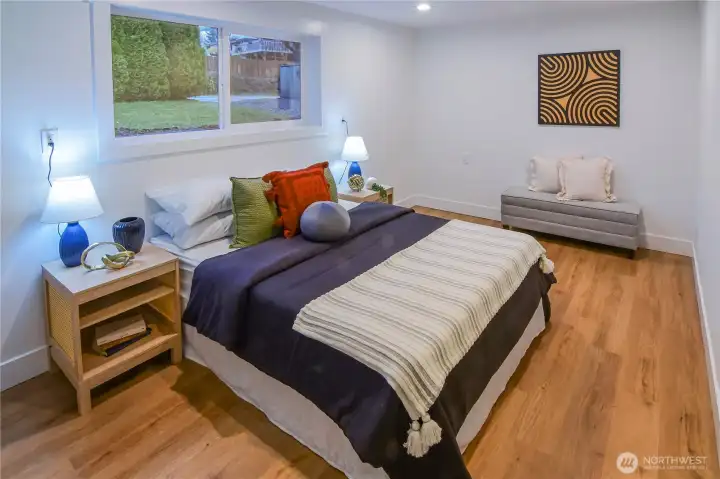 Spacious lower-level bedroom with bright natural light and plenty of room for a full bedroom setup or flexible use.