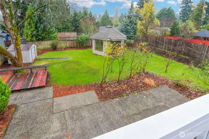 Expansive fully fenced backyard with mature landscaping, multiple fruit trees, a garden shed, and a versatile outbuilding ideal for a studio, office, or hobby space.