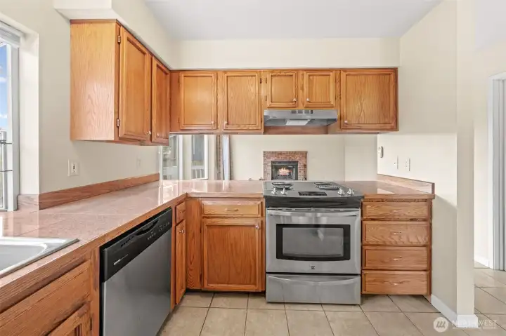Designed for convenience, the kitchen includes ample counter space, stainless steel appliances, and a practical layout that keeps everything within reach. The pass-through window opens to the family room, allowing for easy conversation while cooking.