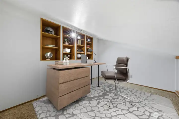 Perfect for a home office or creative retreat, this flexible loft space includes built-in shelving and overhead lighting. The open layout and cozy design make it ideal for productivity or quiet reading.