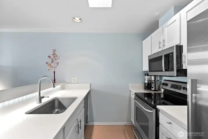 The kitchen has been refreshed with quartz counters and stainless appliances.