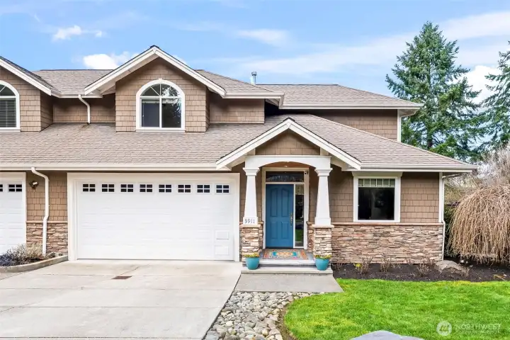 Front exterior of this end-unit townhome-style condo in Cherry Lane Estates, located in Gig Harbor. Private entrance, two-car garage, and beautifully maintained landscaping welcome you home.
