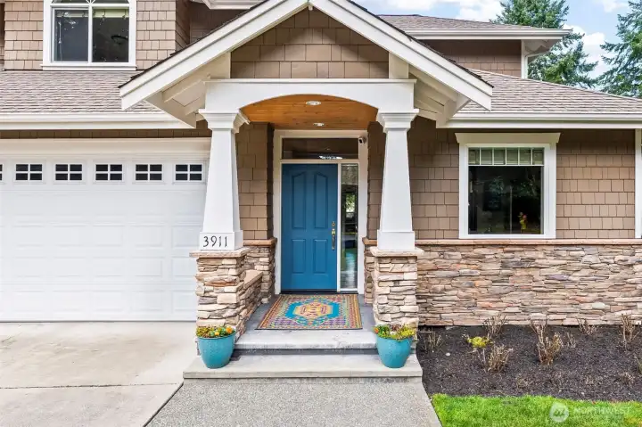 Inviting covered front porch welcomes you to this end-unit townhome-style condo in Cherry Lane Estates, offering a private entrance and peaceful Gig Harbor setting.