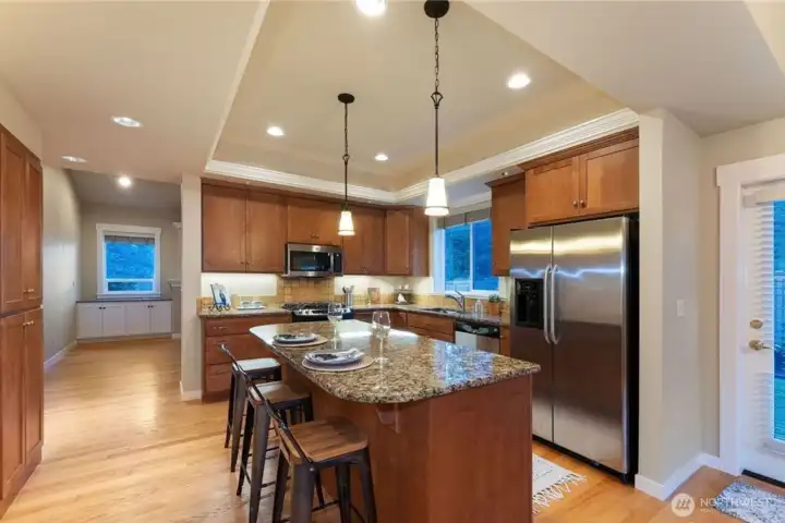 Spacious kitchen featuring granite countertops, durable cabinetry, and a coffered ceiling, creating a stylish and functional gathering space in this Cherry Lane Estates condo.