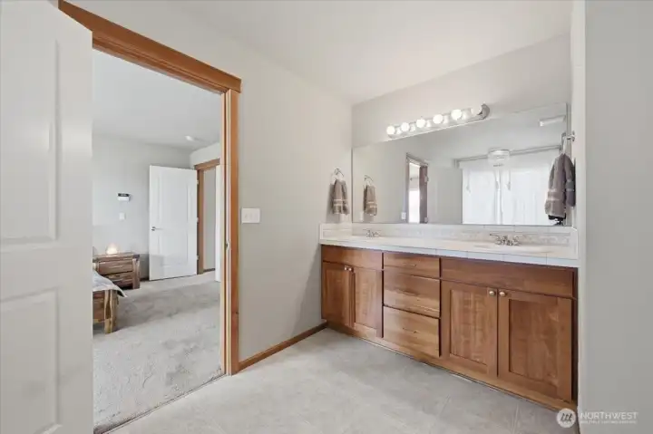 Main bedroom bath with double sinks, tub with view, shower and walk in closet