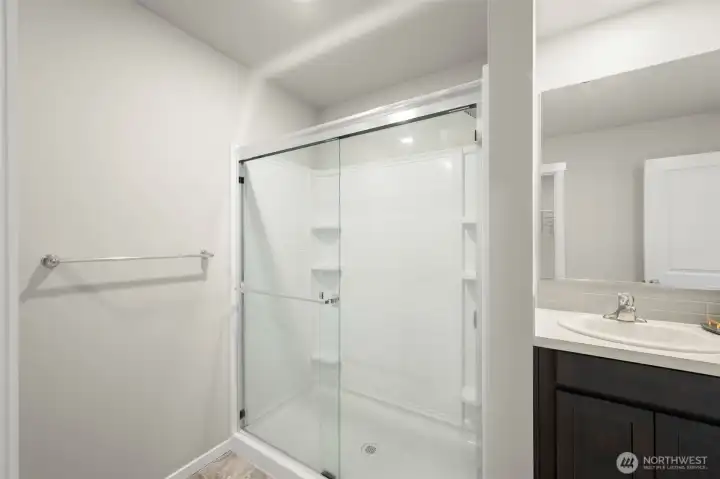 Primary bedroom features a double vanity, walking shower, and huge walk-in closet