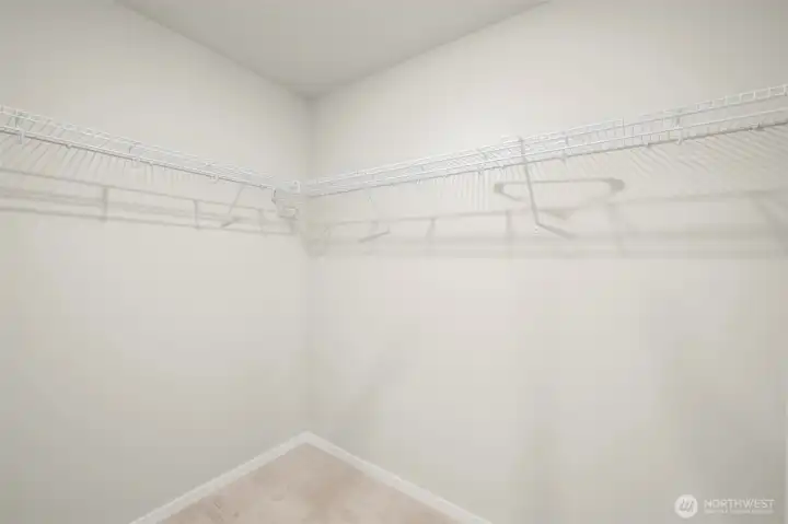 Primary bedroom features a double vanity, walking shower, and huge walk-in closet