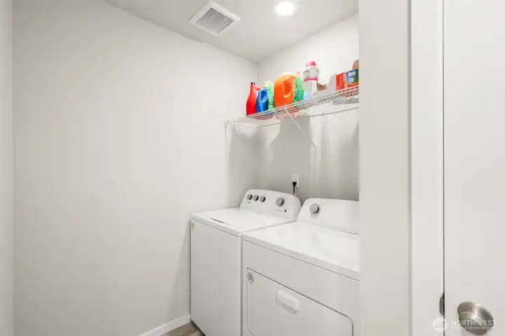 Large upstairs laundry room with overhead storage.