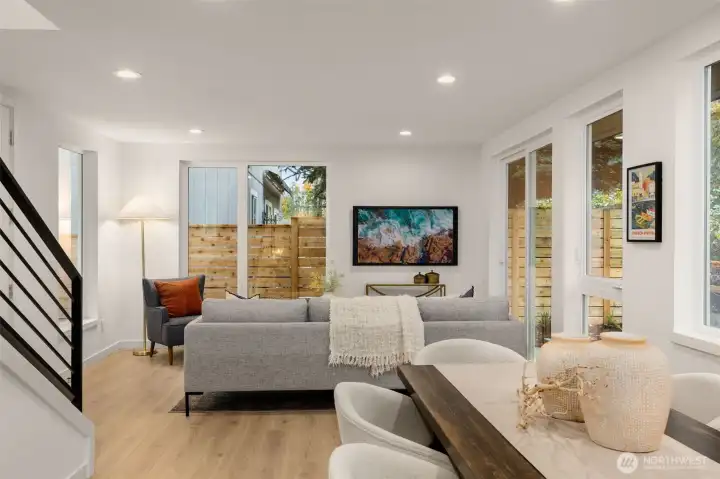 Connected, a cozy living room that shares the same organic glow from the massive windows