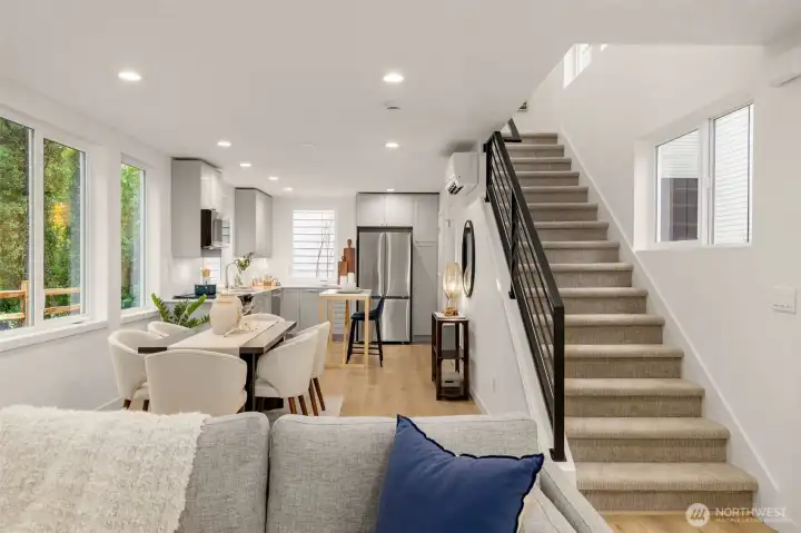 A view of living, dining, and kitchen spaces, each space separated while maintaining a connected flow.