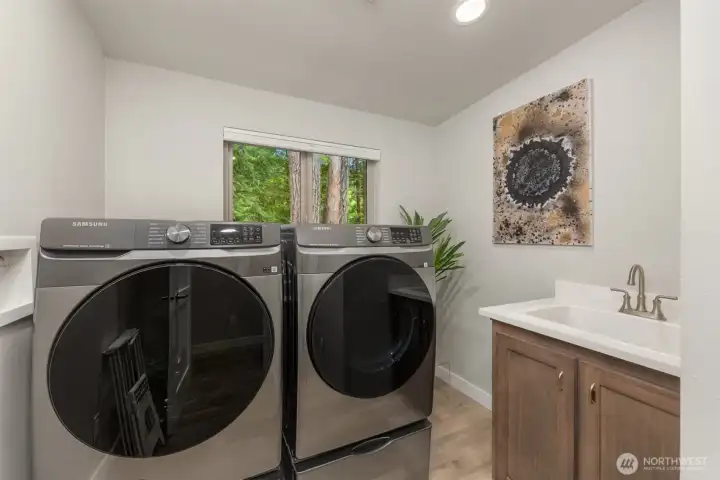 Well-appointed utility room with full-size Samsung washer and dryer, utility sink, and natural light—designed for everyday ease and efficiency. Well-appointed utility room with full-size Samsung washer and dryer, utility sink, and natural light—designed for everyday ease and efficiency.