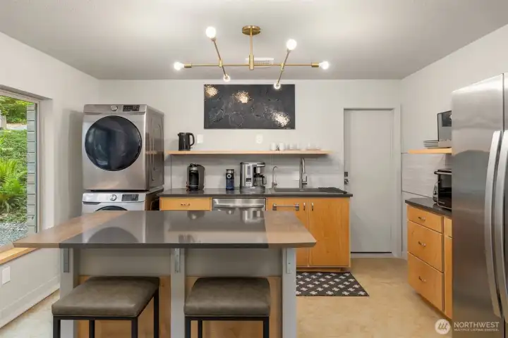 Efficiently designed with modern cabinetry, open shelving, stainless appliances, and an eat-in island, the ADU kitchen blends style and functionality for everyday living. Efficiently designed with modern cabinetry, open shelving, stainless appliances, and an eat-in island, the ADU kitchen blends style and functionality for everyday living.