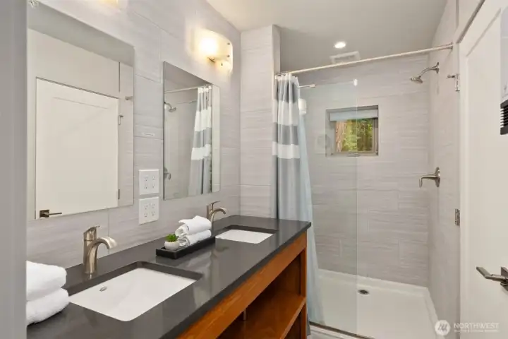 Modern and thoughtfully designed, the ADU bath features clean-lined finishes, dual sinks, and a spacious walk-in shower with contemporary tile surround. Modern and thoughtfully designed, the ADU bath features clean-lined finishes, dual sinks, and a spacious walk-in shower with contemporary tile surround.