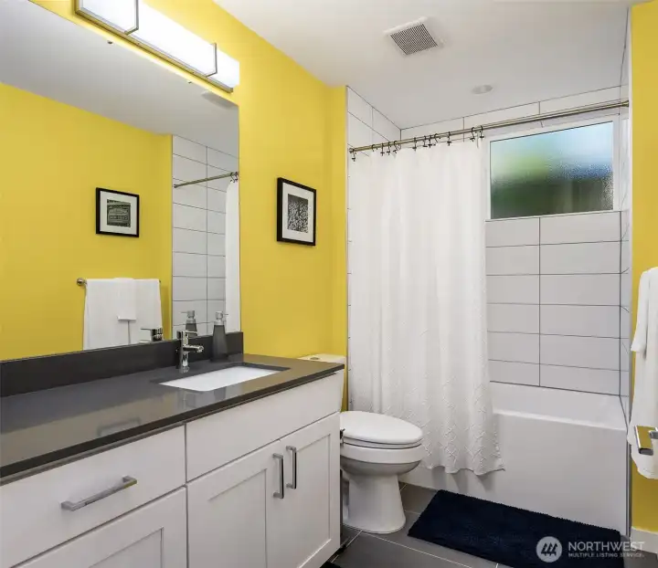 Lower-level bathroom with modern vanity, tile flooring, contemporary fixtures, and convenient access for bedrooms or guests.
