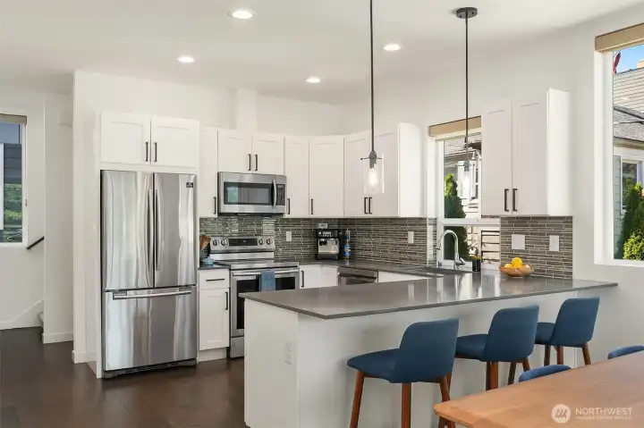Modern kitchen with peninsula bar seating for up to four.