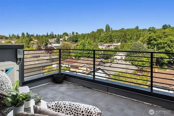 Private upper-level balcony with territorial outlook, modern railing, and outdoor space connected to the home’s primary suite.