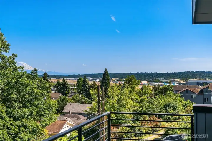 Large private balcony with south-facing territorial views, open sky, and a direct line toward Mount Rainier and Boeing Field.