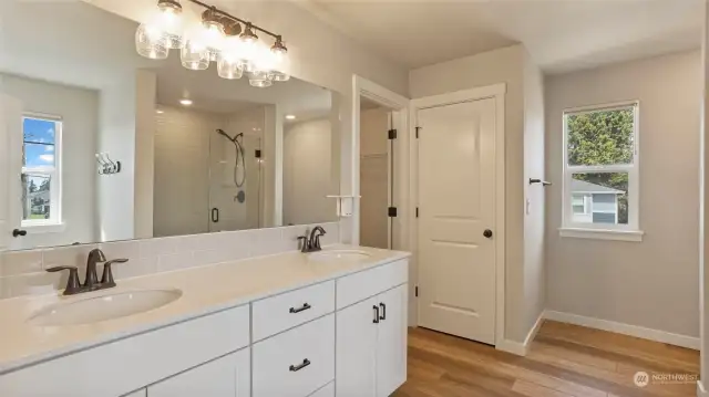 Spacious en-suite features an oversized mirror and vanity space as well as a walk-in shower, linen closet & walk-in closet.