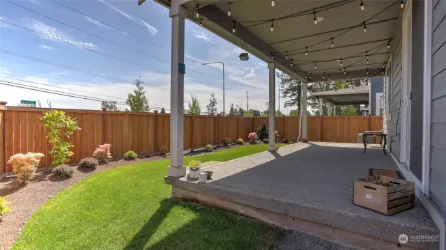 Another angle of the covered patio and the beautiful landscaping that surround the backyard. Another perk of this home is having a sprinkler system in both the front and back yard!