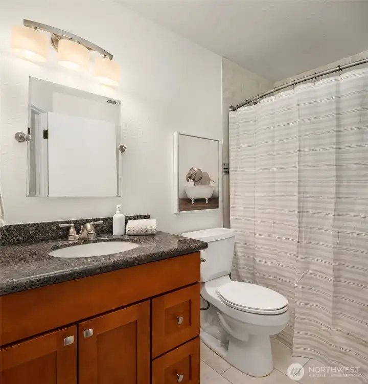 This full bathroom complements the upper level bedrooms. The design is well-appointed.