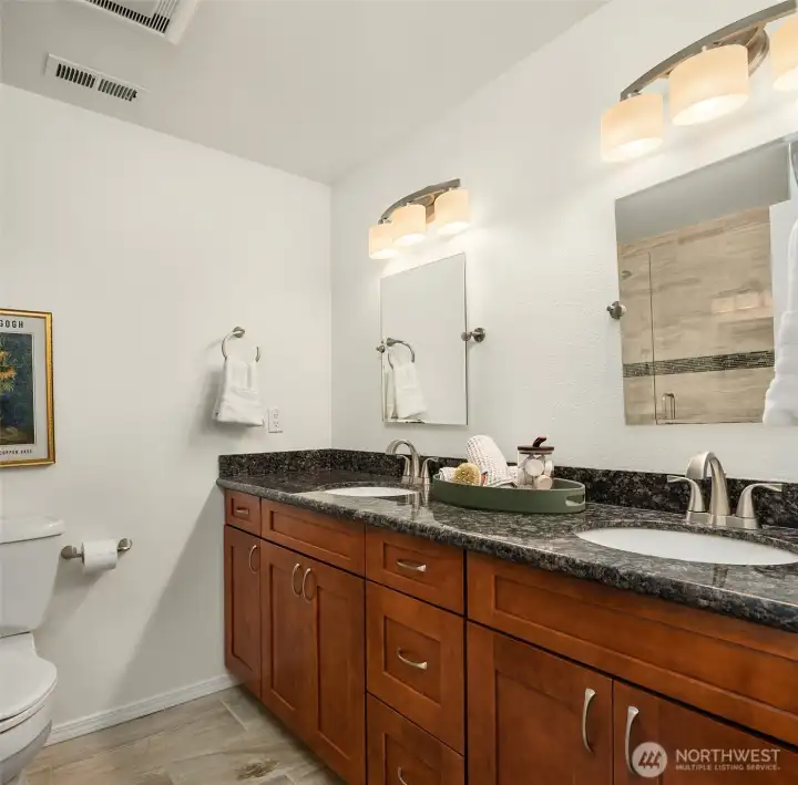 The primary bathroom was refreshed about 10 years ago with timeless finishes - Granite counters, dual vanity, cherry cabinets, mirrors and a step-in shower.