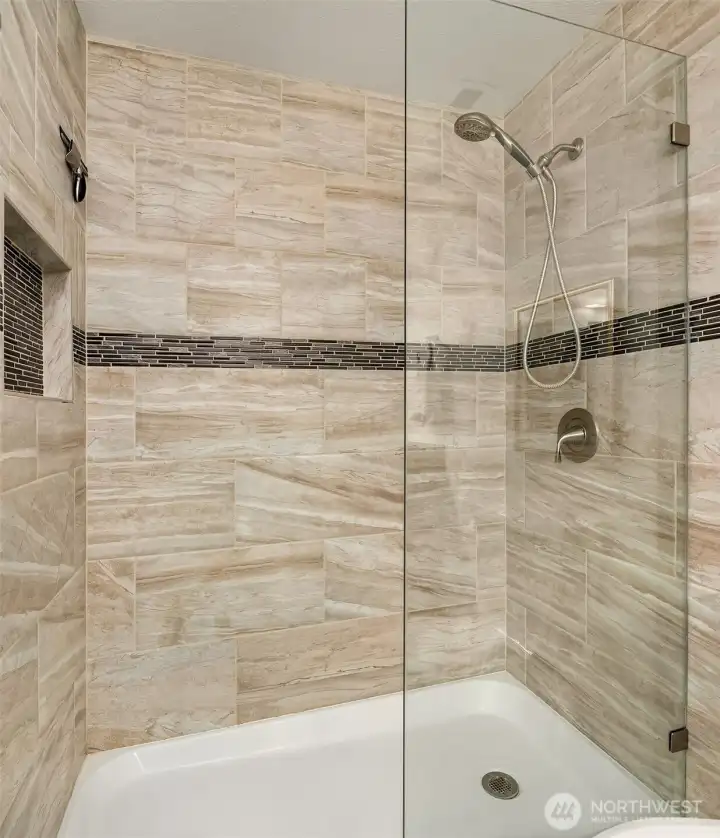 The primary bathroom shower is beautifully appointed.