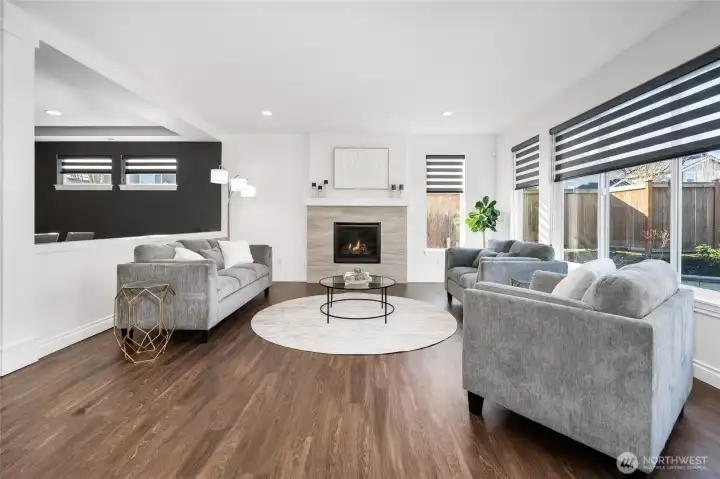 Family room with gas fireplace and custom blinds.