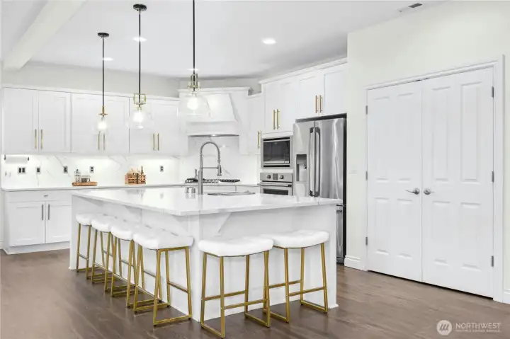 Updated kitchen with large island with sink and Quartz counters, stainless steel appliances and gas cooking.