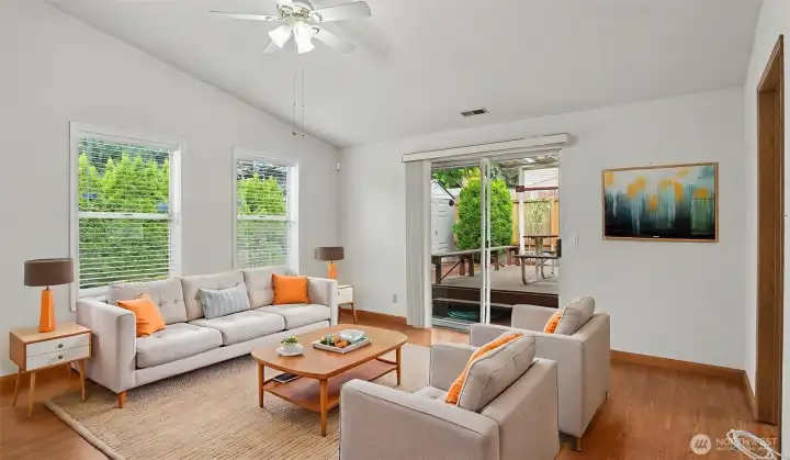 Living room filled with natural light and sliding glass door leading to the deck.