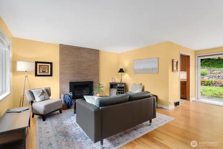 Floor-to-ceiling gas fireplace warms the living room and refinished hardwoods shine.