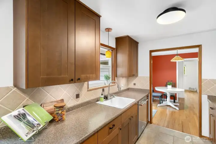 Kitchen connects to the dining area for easy flow and under cabinet lighting brightens the workspace.