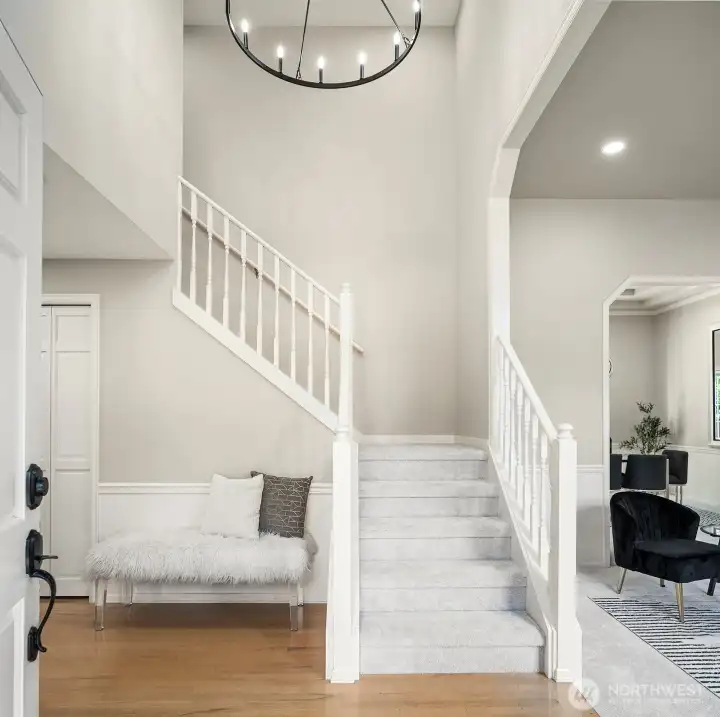 The soaring two-story foyer makes an immediate statement with vaulted ceilings, a elegant staircase, and designer finishes that set the tone for the elevated style carried throughout the entire home.