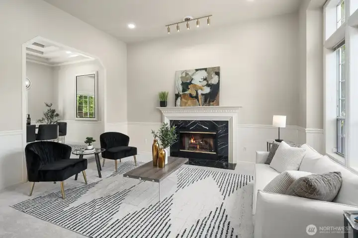 The formal living room showcases the home's refined character with a classic fireplace, recessed lighting, and crisp designer paint that create a sophisticated yet welcoming space for entertaining or quiet evenings at home.