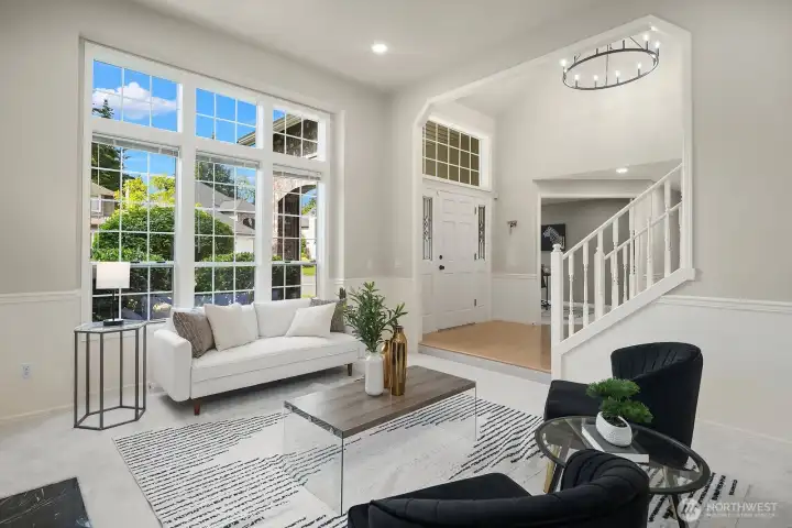 This angle captures the seamless flow between the living and entry areas, with walls of windows flooding the space with natural light and showcasing the fresh designer finishes and open, airy feel that define this home.