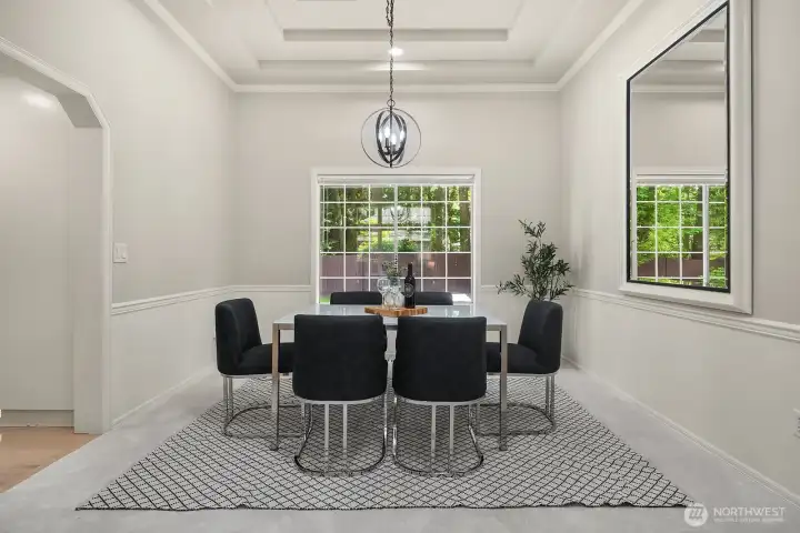The formal dining room offers an elegant setting for gatherings, with a designer pendant light, large window framing the greenery outside, and refined finishes that make every meal feel like an occasion.