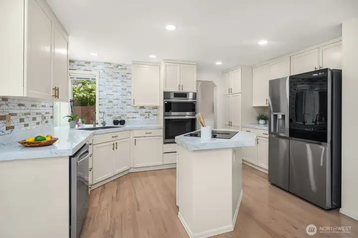 The kitchen's thoughtful layout maximizes both counter space and storage, with the central island, recessed lighting, and premium finishes coming together to create a space that will delight any home chef.