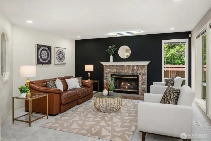 The inviting family room features a dramatic accent wall, cozy fireplace, and large windows overlooking the backyard, creating a warm and relaxed gathering space that balances bold design with everyday comfort.
