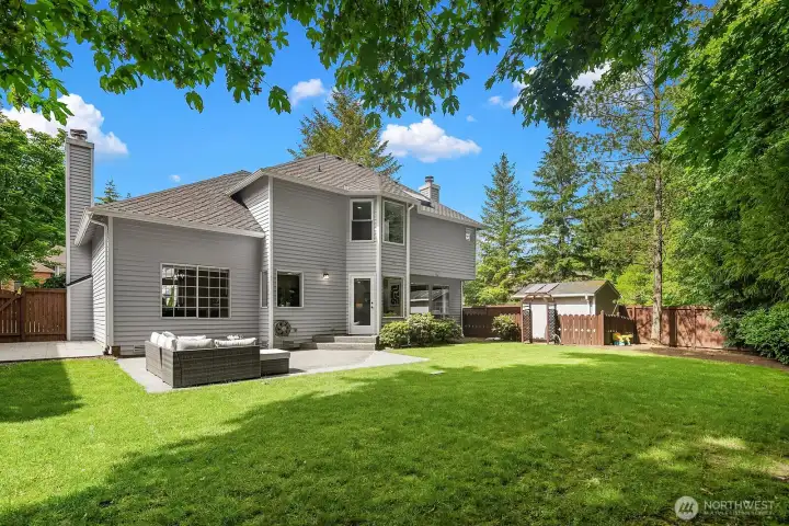 The expansive fully fenced backyard offers a generous lawn, a large patio ideal for outdoor entertaining, and direct access to the serene greenbelt trail beyond, delivering a rare level of privacy and natural beauty.