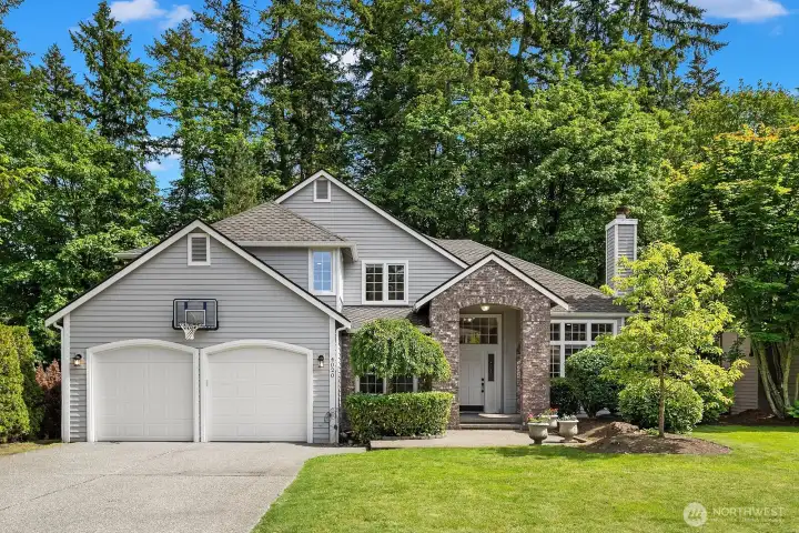 A beautifully maintained Murray Franklyn home in the coveted Ashley Park community of Klahanie, featuring classic Northwest curb appeal with warm siding, an oversized two-car garage, and lush mature landscaping that signals the quality and care found throughout.