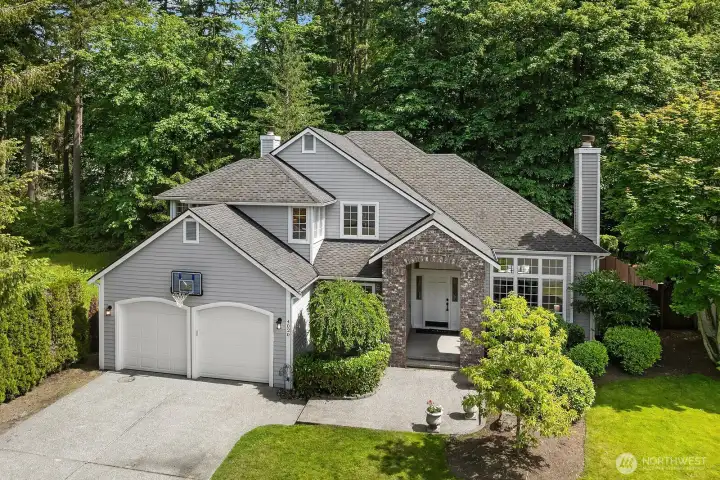 A second exterior view highlights the home's classic stone accents, oversized two-car garage, and beautifully landscaped front yard, reinforcing the strong curb appeal and well-cared-for character of this exceptional Klahanie home.
