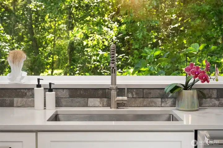 You'll appreciate the flush mount stainless steel farm sink looking out onto private greenbelt and abundant mature plantings.