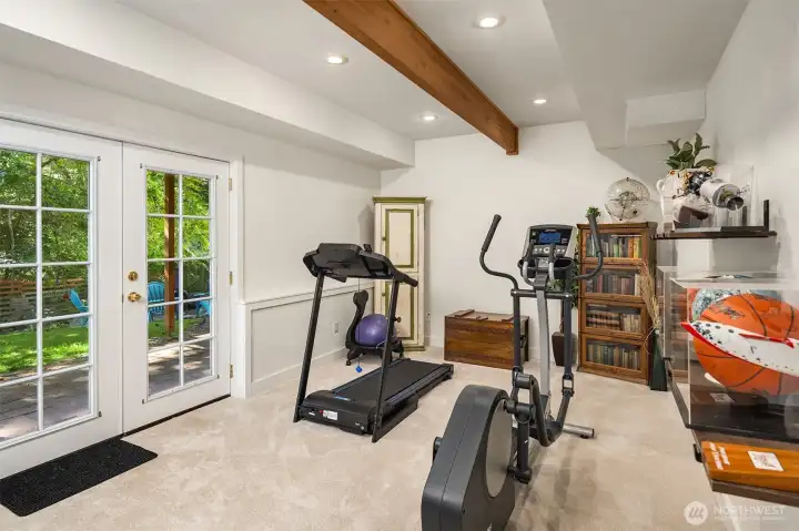 Enjoy this ultimate flex space in this bright lower level, complete with recessed lighting and a striking accent beam. The glass doors seamlessly connect your indoor workout, hobby area or recreation room to the backyard.