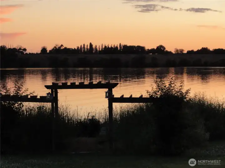 Sunset over the lake. Fire pit and boat launch with dock.