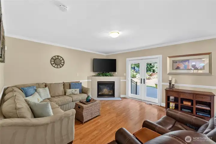 Living area adjacent to kitchen leads with fireplace and French door to outside oasis Living area adjacent to kitchen leads with fireplace and French door to outside oasis