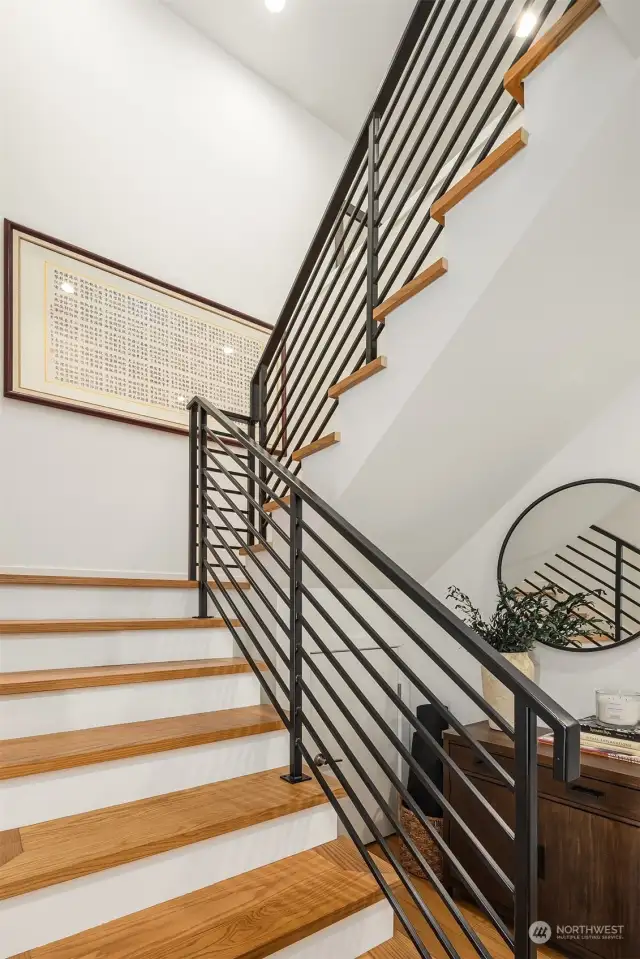 Modern iron railing and warm wood stairs take you to the second level.