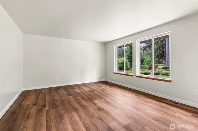 Primary bedroom with large windows overlooking private oasis backyard